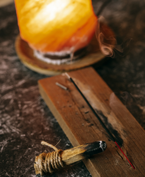 Palo santo releasing smoke on a table with incense. Palo santo releasing smoke on a table with incense.